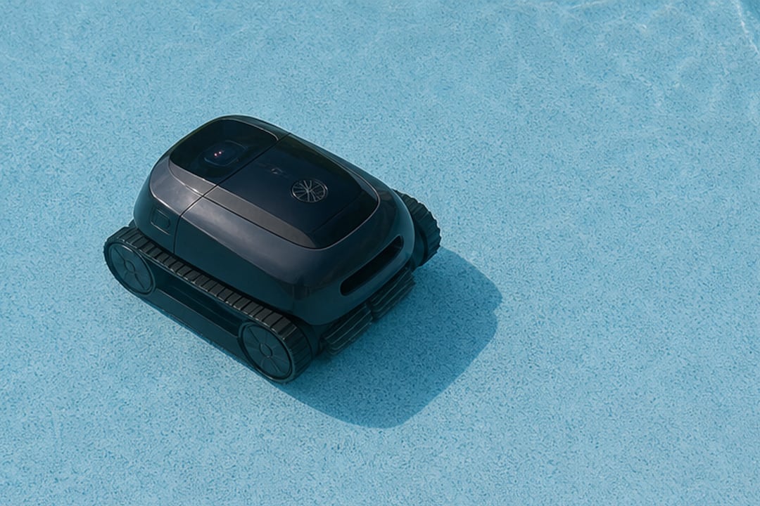 Robot nettoyeur sans fil se déplaçant sur le fond bleu clair d’une piscine équipée d’un liner