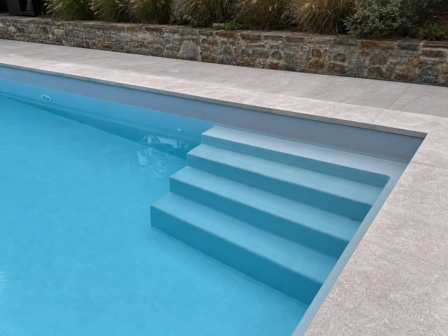 Visualisation d’une piscine avec escalier et ancien revêtement marqué près de la ligne d’eau